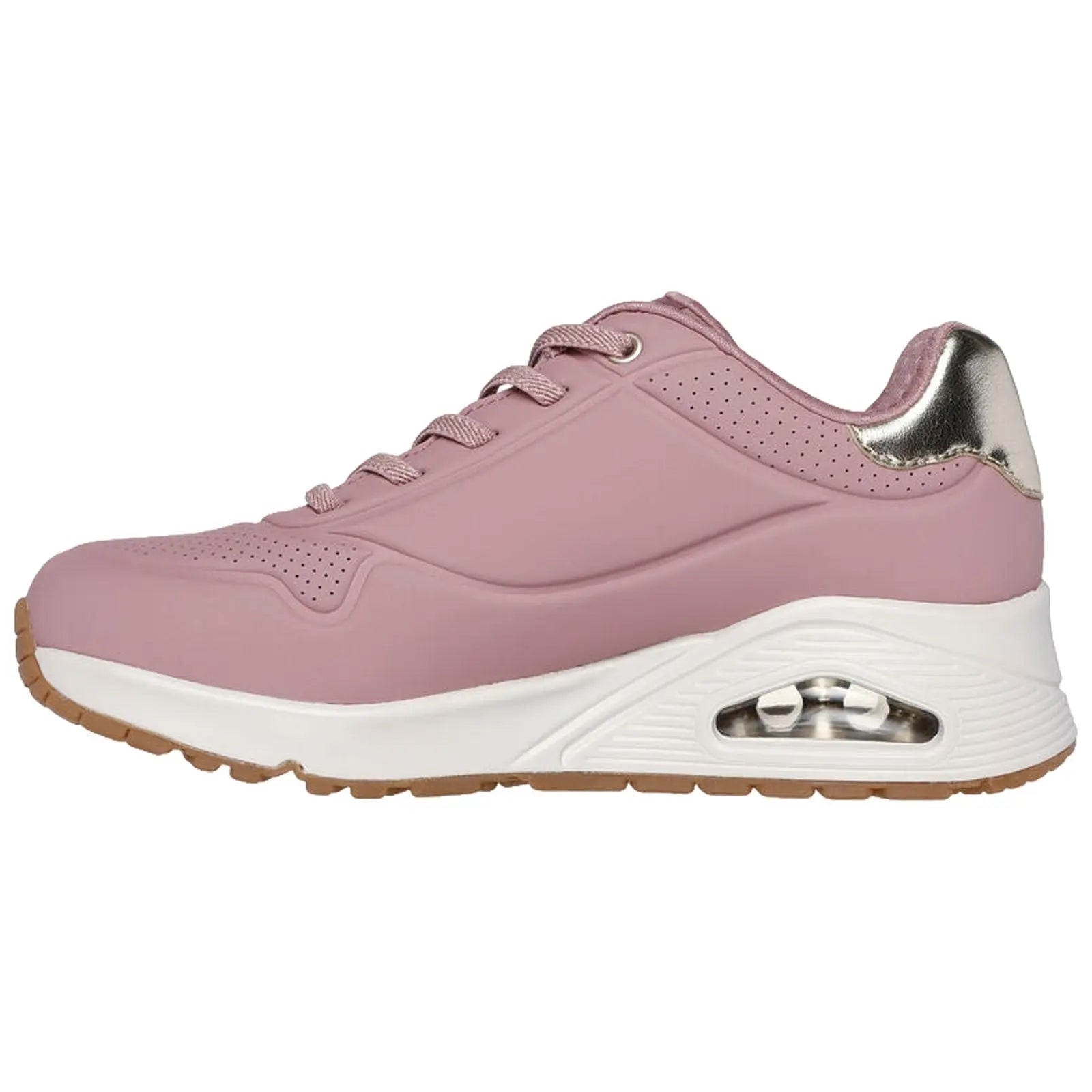 A pink athletic shoe with a shiny gold accent is positioned on a white background showcasing its sleek design perforations and visible air cushioning in the sole.