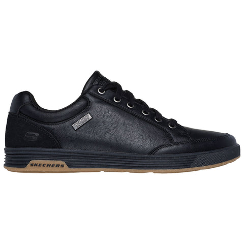 Black leather sneaker with a rounded toe and rubber sole is positioned sideways showcasing its design and features in a plain background suggesting a retail display or online listing