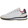 A white athletic shoe with red and navy accents sits on a light background showcasing its sleek design and textured materials intended for sports or casual wear.