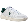 A white athletic shoe with green accents is displayed angled to show its clean lines and texture. The shoe features a logo on the side and a textured rubber sole.