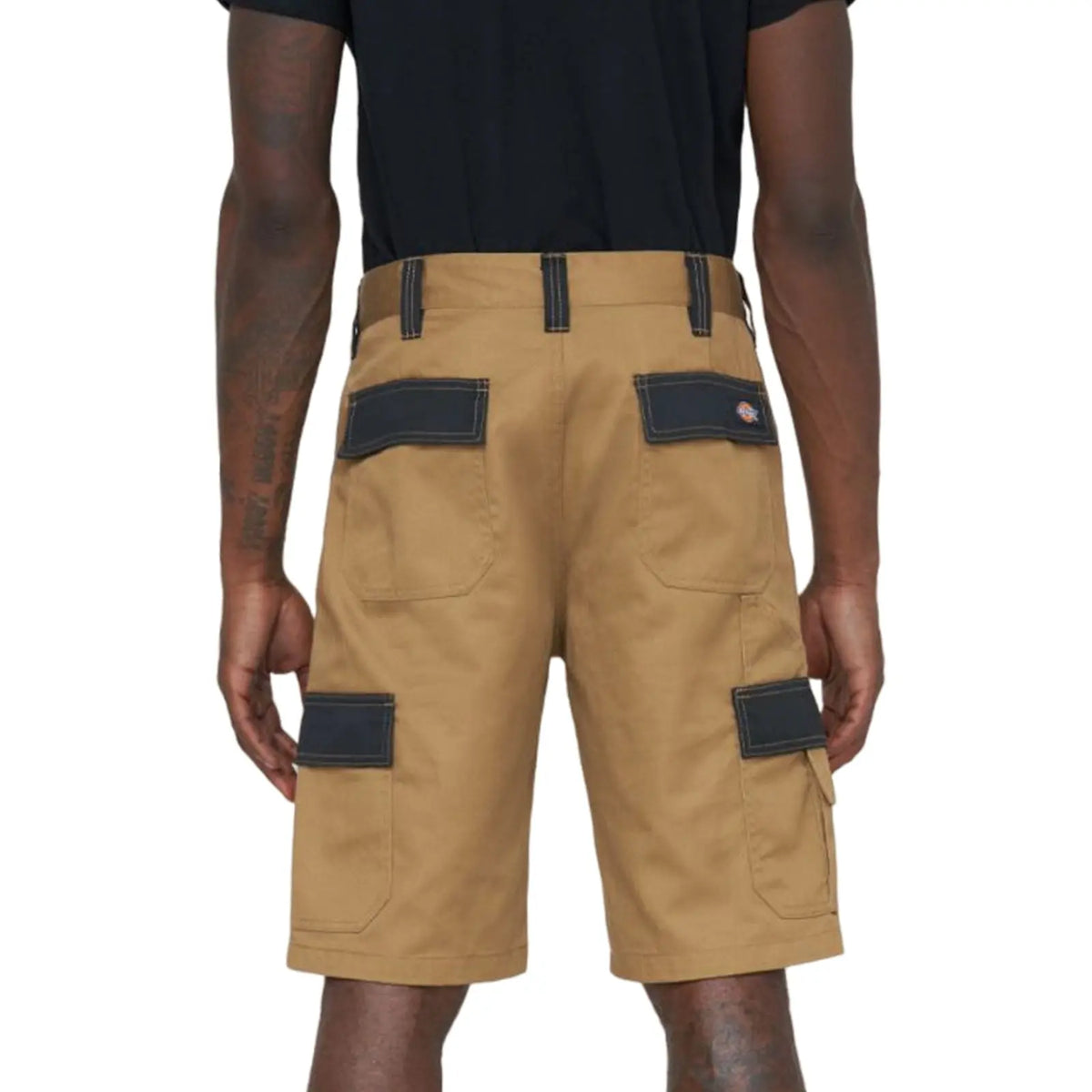 Khaki cargo shorts with multiple pockets are being worn by a person facing away from the viewer, set against a plain background. The shorts have dark patches on the pockets.