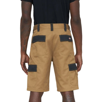 Khaki cargo shorts with multiple pockets are being worn by a person facing away from the viewer, set against a plain background. The shorts have dark patches on the pockets.
