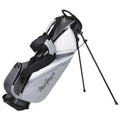 A golf bag stands upright on three legs with a grey and white design featuring a logo. It has a carrying strap and multiple compartments for carrying golf clubs and accessories.