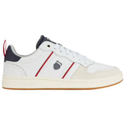 A white sneaker features a smooth leather upper with red and navy stripes an emblem on the side and a gum sole positioned against a neutral background.