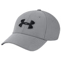 A gray baseball cap features a black Under Armour logo on the front while sitting at an angle against a plain background providing a clean visual focus on the hat.