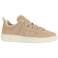 A tan suede sneaker with white rubber sole features light stripes and a lace-up design showcasing casual footwear suitable for everyday activities in an urban environment.