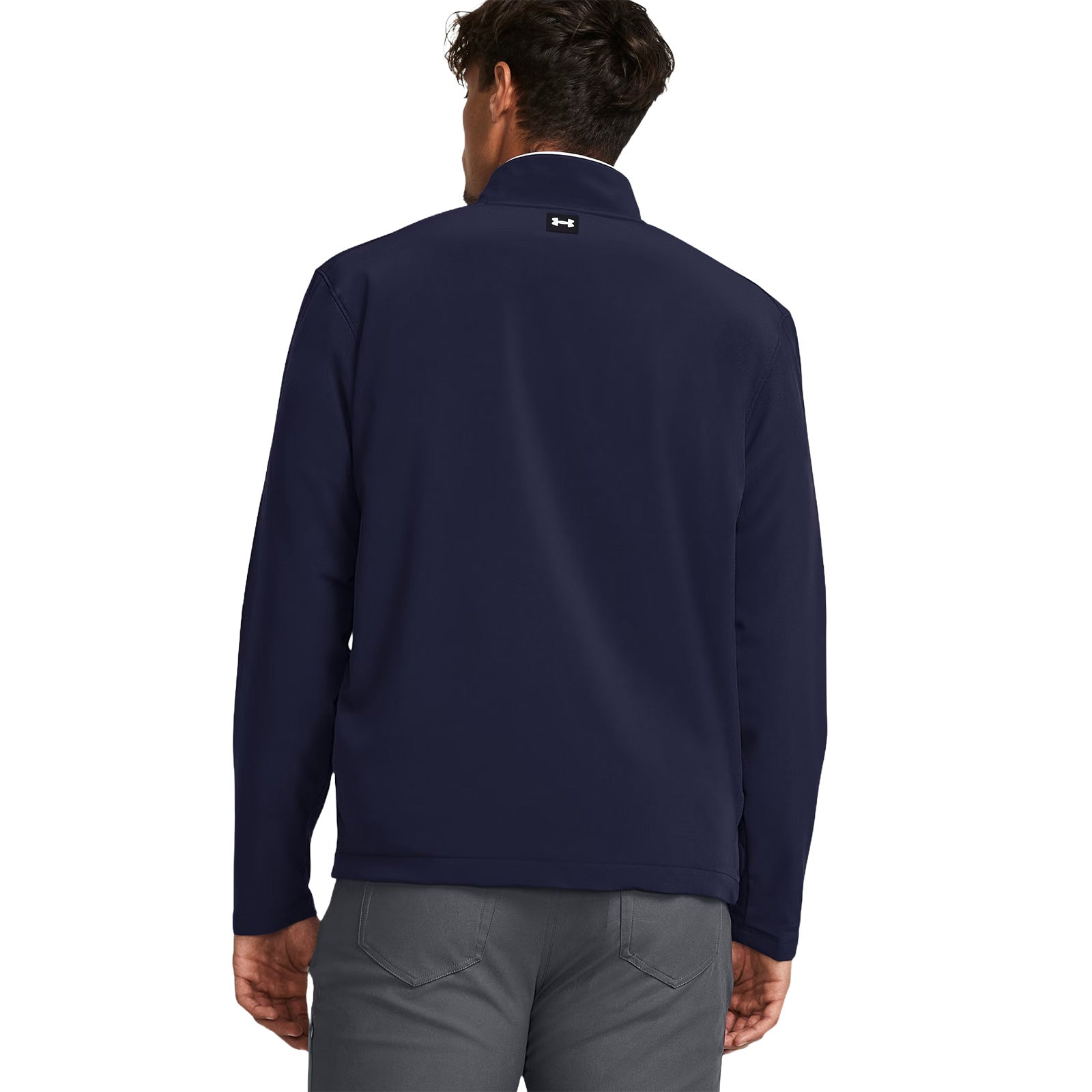 A person wears a navy blue jacket standing with their back facing the viewer in a neutral background suggesting an outdoor or casual setting.