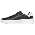 A black leather sneaker with a white sole features a sleek design and round laces situated on the left side, showcasing a modern sporty style against a plain white background.