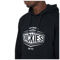 A person wearing a black hoodie with a prominent white logo is facing slightly to the right, showcasing the logo and text on the front designed for durability and casual style. Text: QUALITY WORKWEAR DICKIES SINCE 1922