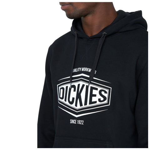 A person wearing a black hoodie with a prominent white logo is facing slightly to the right, showcasing the logo and text on the front designed for durability and casual style. Text: QUALITY WORKWEAR DICKIES SINCE 1922