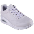 A light gray sneaker is positioned upright showcasing its smooth surface and perforated details. The shoe features matching laces and a cushioned sole with visible air cushioning at the heel.