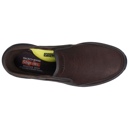 A brown slip-on shoe features a textured leather exterior and a cushioned interior labeled with Skechers and gogamat branding in yellow and red on the insole providing comfort and odor reduction.
