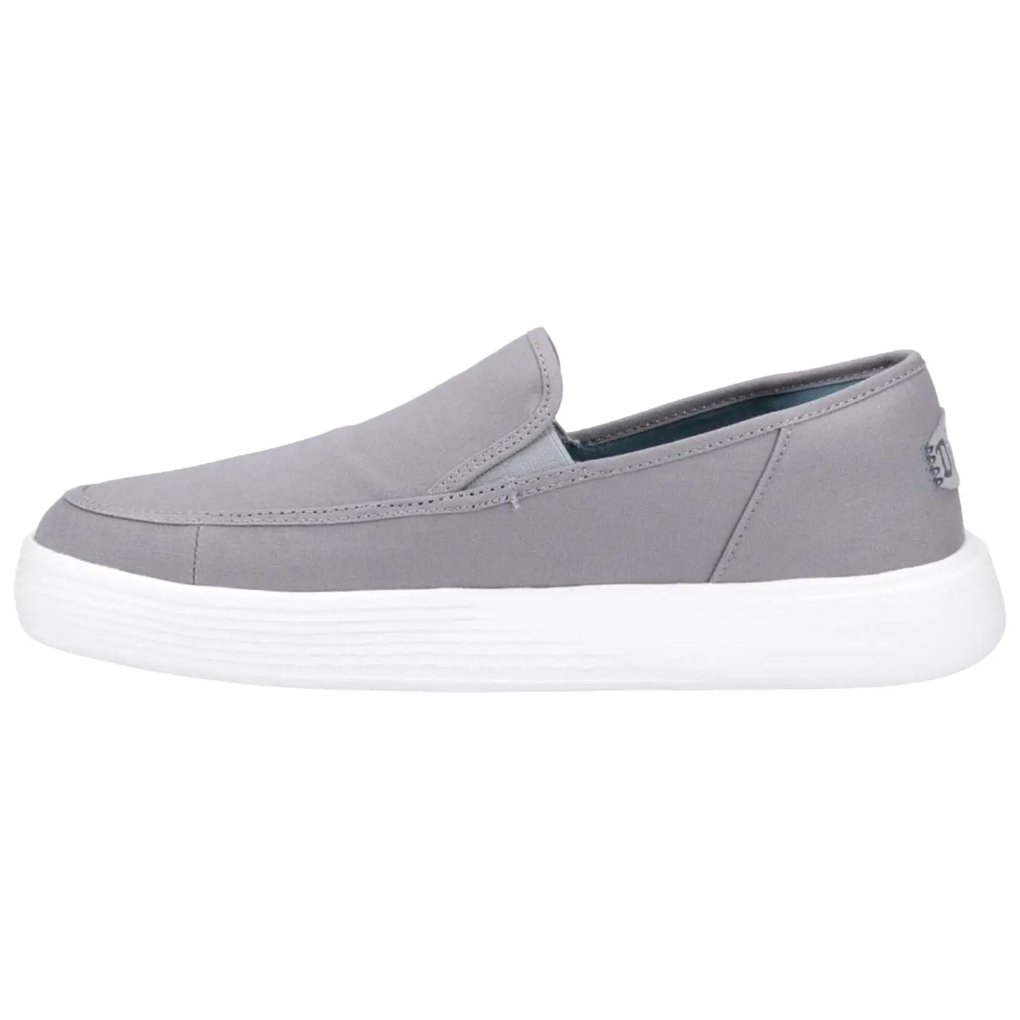A gray slip-on shoe rests on a white background showcasing a minimalistic design with a textured rubber sole providing a casual look suitable for everyday wear.