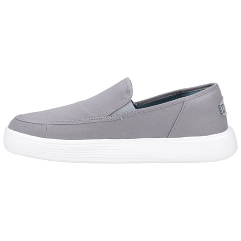 A gray slip-on shoe rests on a white background showcasing a minimalistic design with a textured rubber sole providing a casual look suitable for everyday wear.