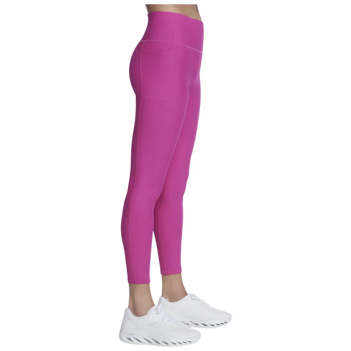 Pink leggings are worn by a person standing sideways showcasing a fitted design with an elastic waistband and side pocket in a neutral background featuring white athletic shoes