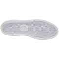 A white shoe sole with a textured pattern is displayed facing down on a neutral background emphasizing its design and grip features without any surrounding context or visible elements.