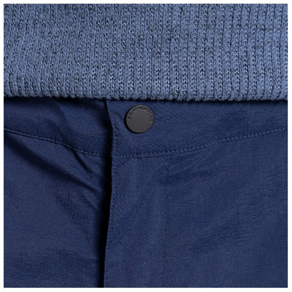 A navy blue fabric waistband features a black button marked Craghoppers while underneath is a textured light blue knitted garment, suggesting a layered clothing style in a casual setting.