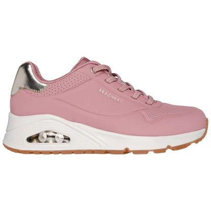 A pink athletic shoe with a sleek design features a shiny metallic heel and perforated detailing while sitting against a white background showcasing its stylish and sporty appearance.