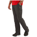 A person stands with one hand in their pocket wearing dark cargo pants and boots. They are dressed in a red shirt and appear to be ready for outdoor activities.