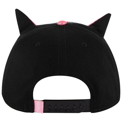 A black cap with cat-like ears and a pink glittery accent on top sits upright showcasing its playful design and branded label at the back.