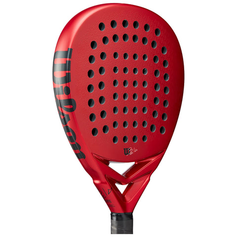 A red paddle bat features a perforated hitting surface and a black handle. It is designed for racquet sports, showcasing a sleek, modern aesthetic ideal for competitive play.