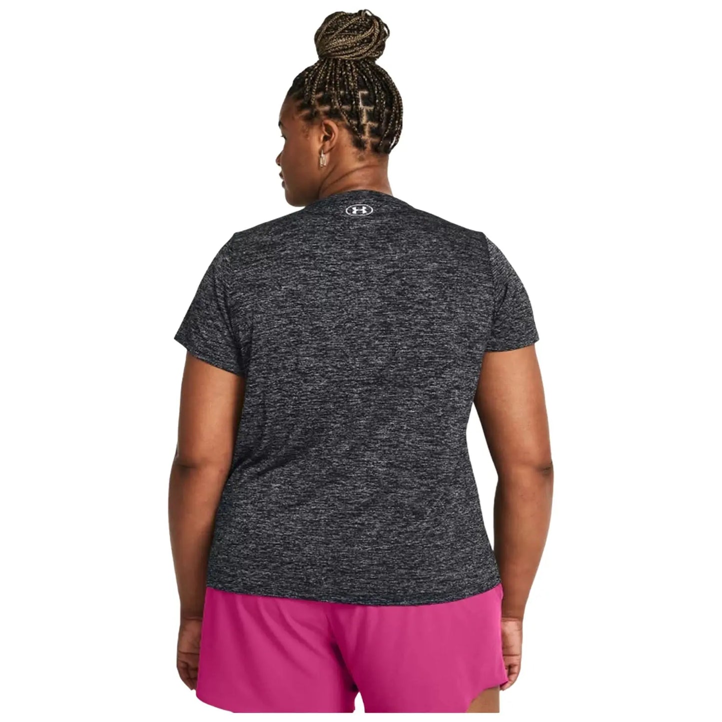 A person with braided hair wears a dark gray athletic shirt and pink shorts while facing away, suggesting readiness for exercise in a casual outdoor or indoor environment.