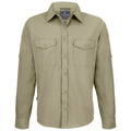 A long-sleeved, light olive shirt with two chest pockets is displayed straight-on, featuring a button-up front and a collar, suitable for casual or outdoor wear.