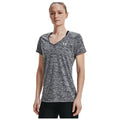 Under Armour Ladies Twist Tech V-Neck T-Shirt 1258568 A woman stands confidently wearing a gray athletic shirt with a V-neck and short sleeves, showing a casual yet sporty vibe in a neutral background.