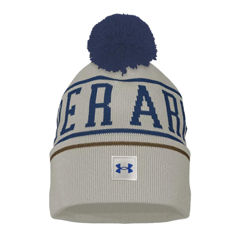 A gray knit beanie with a blue pom-pom on top features the word UNDER ARM in large blue letters and a white Under Armour logo at the bottom.