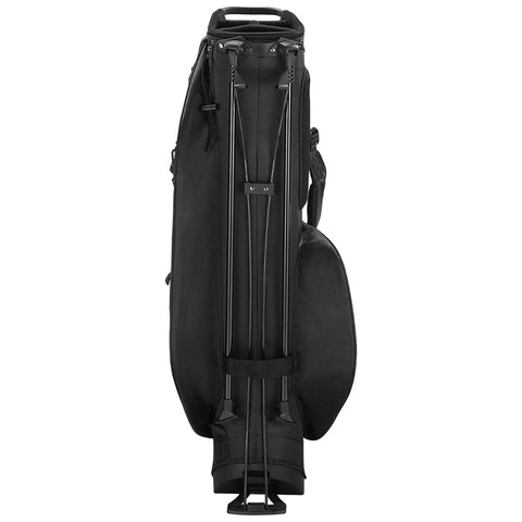 A black golf travel bag stands upright with telescopic handles extended providing a means to roll it. The bag is designed for transportation of golf clubs and equipment.