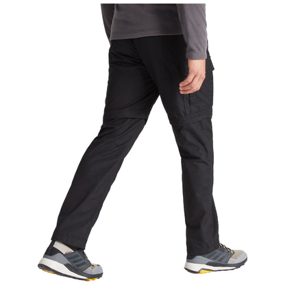 A person is walking in black cargo pants and gray shoes with a textured sole in a neutral setting, suggesting an active or outdoor context.