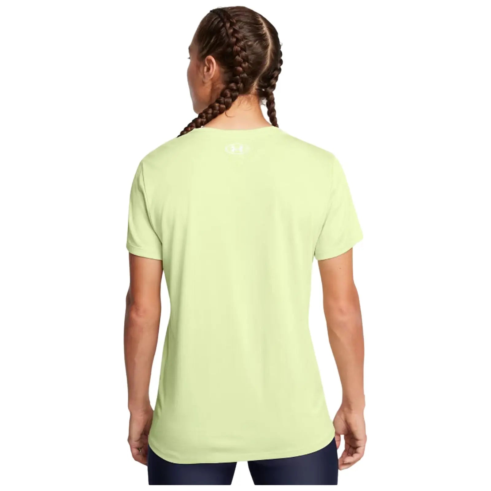 A person with braided hair wears a light green athletic t-shirt facing away from the viewer in a simple, unobtrusive space.