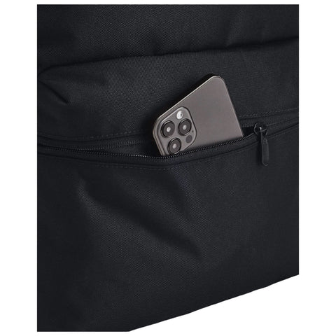 A black fabric bag contains a partially visible smartphone nestled in a zippered pocket showcasing its sleek design and camera layout in a casual storage setting.