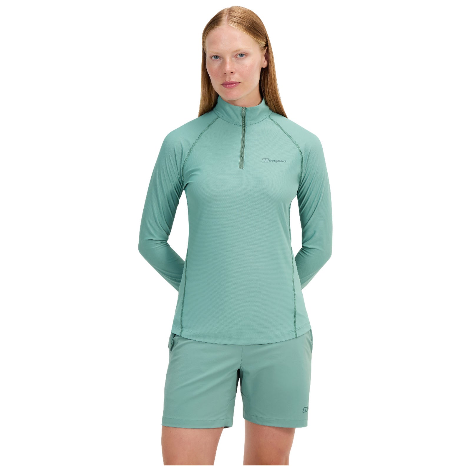 A blue long-sleeved shirt with a quarter zip is displayed from the front and back revealing its smooth fabric and contrasting stitching details while showing the brand logo on the front.