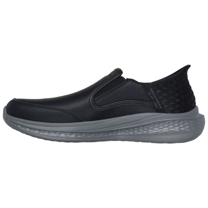 A black slip-on shoe features elastic side panels and a textured heel. It rests on a lightweight gray sole, suitable for casual wear and easy to put on.