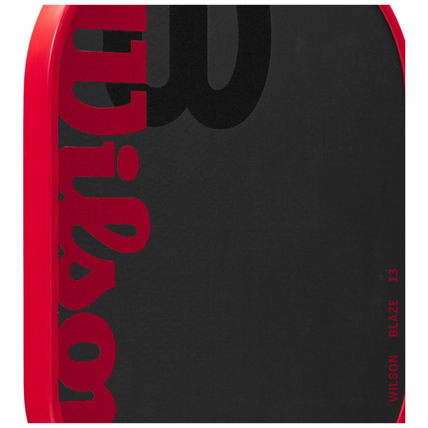 A red paddle with a black hitting surface displays the word "Wilson" prominently in red and black. The paddle is designed for racquet sports, likely in a sporting goods context.