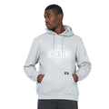 A man wearing a gray hoodie with the brand name Dickies displayed prominently stands with his hands in the pockets gazing slightly to the side against a plain background.