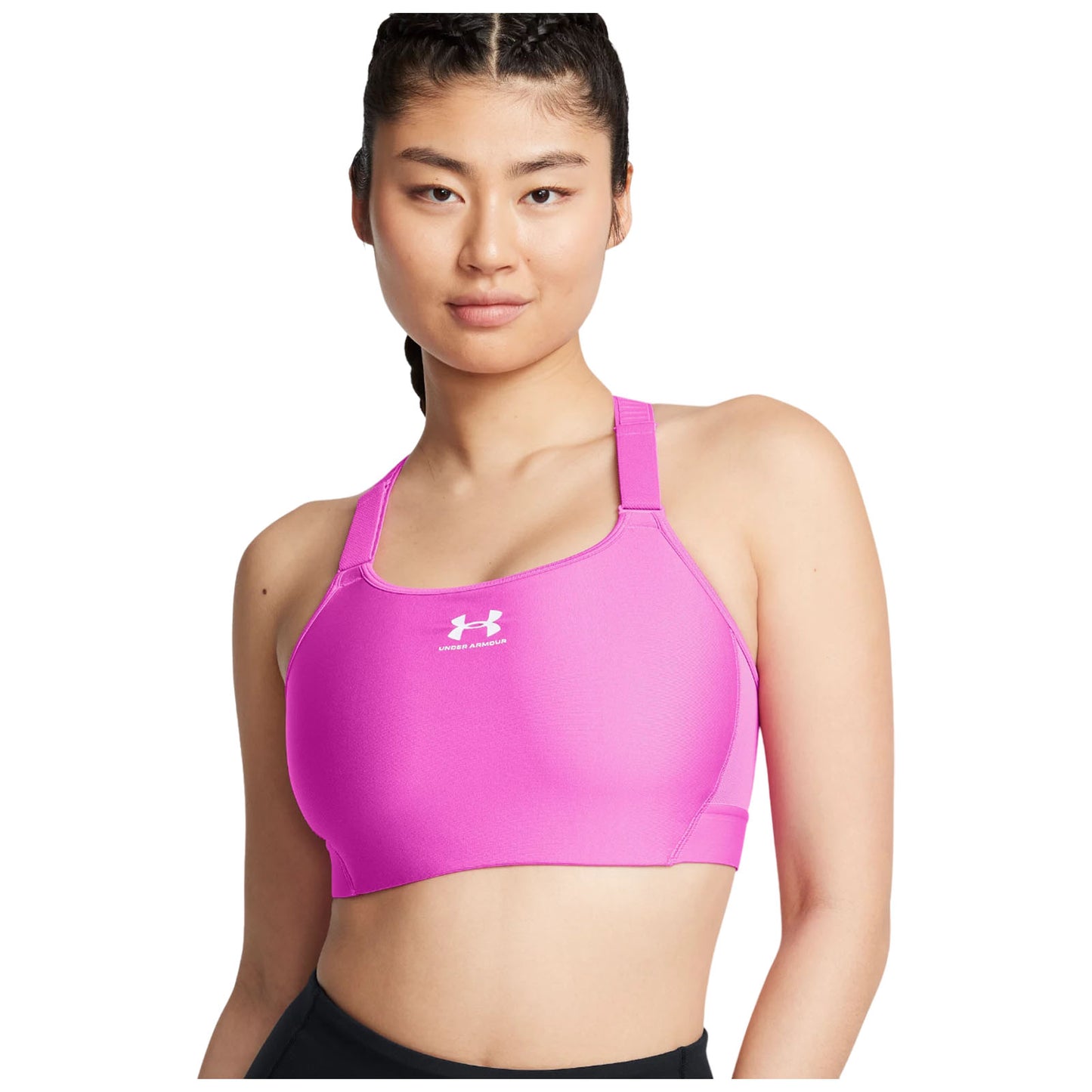 A person is wearing a pink sports bra featuring a logo on the front and is looking confidently at the viewer against a plain white background.
