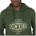 A man is wearing a green hoodie featuring a large logo that reads "DICKIES" with the phrase "QUALITY WORKWEAR SINCE 1922" below, suggesting a casual and work-oriented style.
