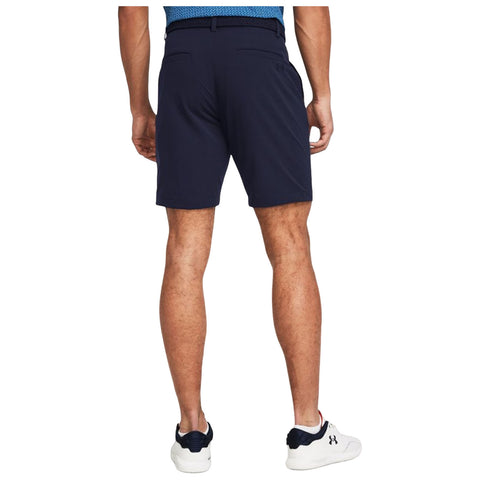 A person stands with their back to the viewer wearing navy shorts and white athletic shoes in a neutral setting emphasizing the clothing without any specific context or detailed background.