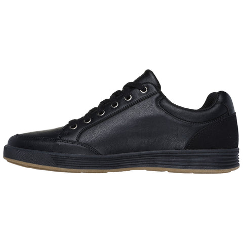 A black sneaker is positioned sideways with a smooth leather exterior and six eyelets for laces the rubber sole has a textured grip surface suitable for casual wear or activities