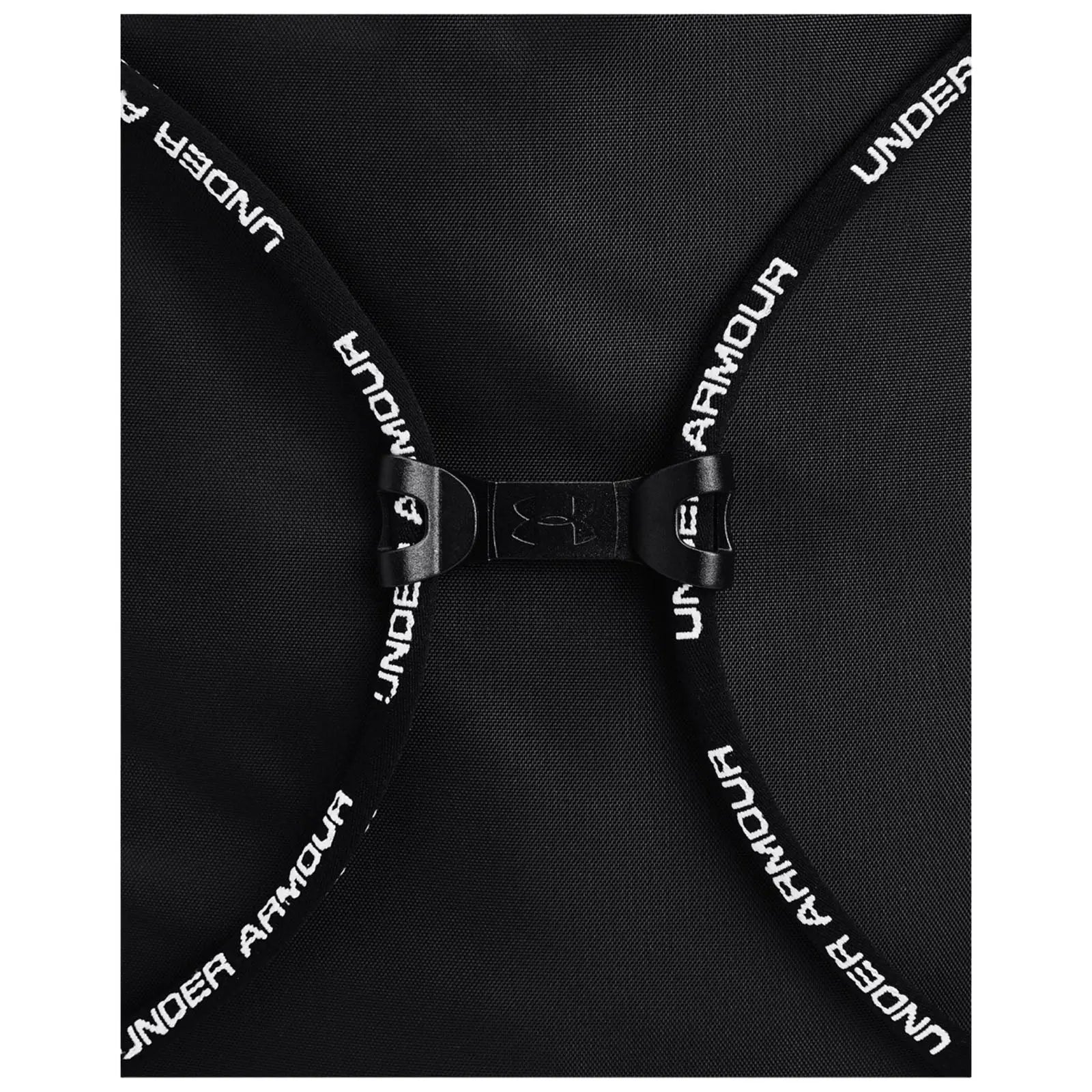 A black backpack features a clasp with adjustable straps displaying "UNDER ARMOUR" text the bag is positioned flat showing its design and closure mechanism.
