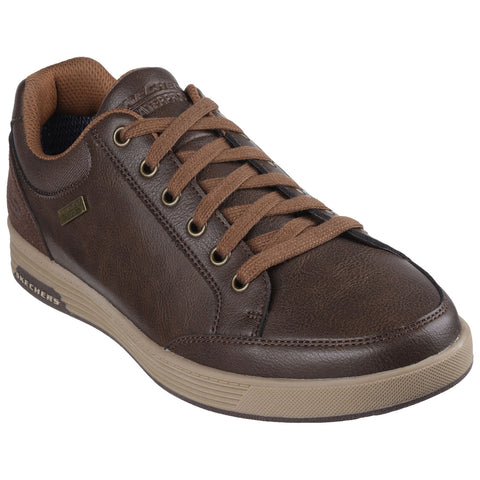 A brown leather sneaker features round laces and a textured sole showcasing a casual design suitable for everyday wear. It is positioned against a plain white background.