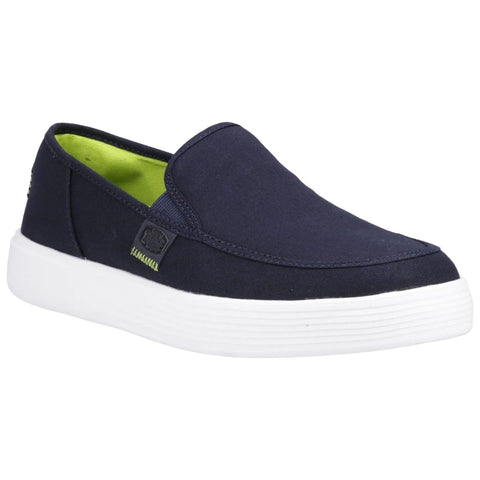 A navy slip-on shoe features a breathable fabric upper and a white rubber sole with textured detailing giving it a casual appearance suitable for everyday wear. The interior has a bright green lining.