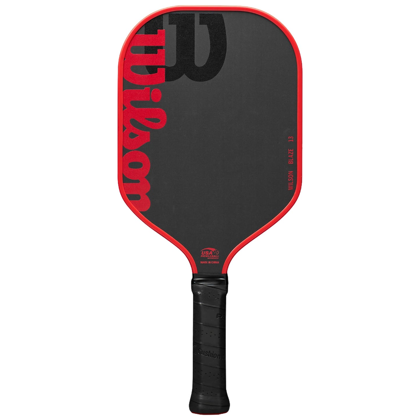 A pickleball paddle with a red outline and a black surface prominently features the word "Wilson" in bold lettering while resting upright against a neutral background.
