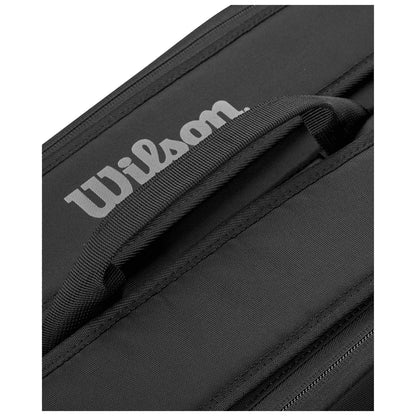 A black sports bag with a prominent white "Wilson" logo on the side is positioned at an angle revealing its handle and zipper area.