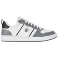 A gray and white sneaker is positioned on a flat surface with a sleek design featuring a logo on the side and laces threaded through eyelets creating a casual sports aesthetic.