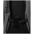 A close-up view of a gray backpack features a black mesh area and adjustable straps with buckles securely fastened showcasing its design and functionality for outdoor or sports use. Text reads "Wilson."