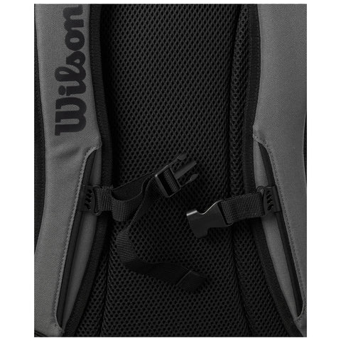 A close-up view of a gray backpack features a black mesh area and adjustable straps with buckles securely fastened showcasing its design and functionality for outdoor or sports use. Text reads "Wilson."