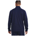A person is standing with their back facing the viewer wearing a navy blue jacket with a collar in a plain white background. Their hands rest at their sides.